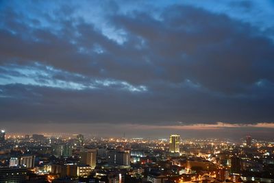 Illuminated buildings in city against sky at night