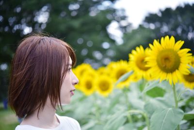 Portrait of woman against yellow flowering plants