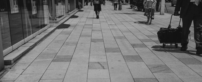 Low section of people walking on tiled floor