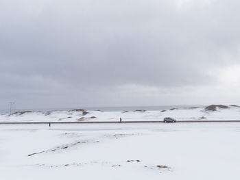 Scenic view of snow covered land against sky