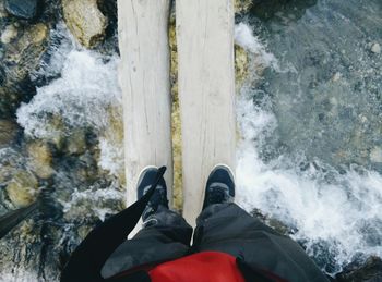 Low section of person standing in water