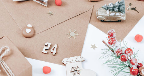 One handicraft envelope with wooden number 24, cookies, christmas decor and a spruce branch .