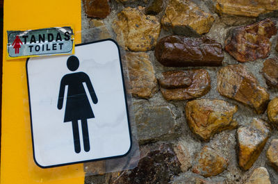 Close-up of toilet sign on wall