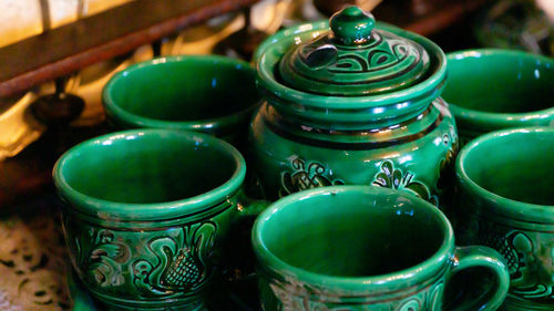 Close up view of colorful artisanal ceramic tea cups and teapot pottery handcrafted