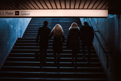 Rear view of people standing on staircase