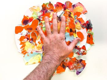 High angle view of human hand against colored background