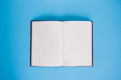 Directly above shot of open book against blue background