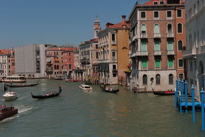 Boats in canal amidst buildings in city