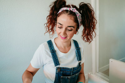 Smiling woman working over wood at home