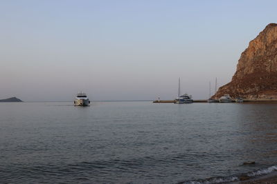 Sailboats in sea against clear sky