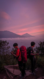 Rear view of family walking on mountain during sunset