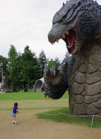 Statue on field against sky