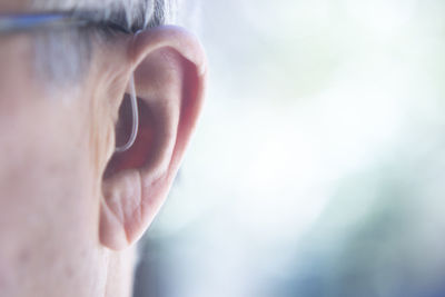 Close-up of man with hearing aid against blurred background