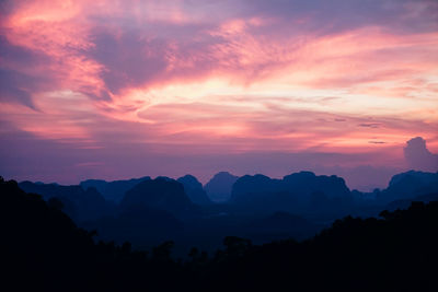 Scenic view of silhouette mountains against orange sky