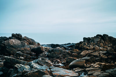 Rocks by sea against sky
