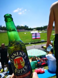 Close-up of beer glass bottle against sky