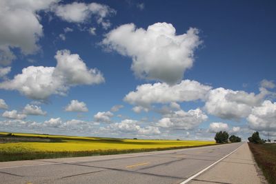 Road by landscape against sky