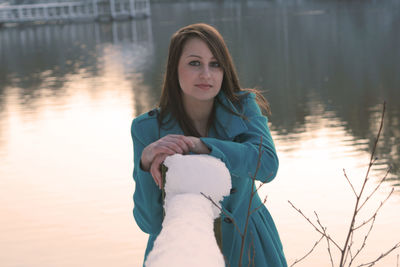 Portrait of woman standing by lake