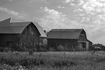 Abandoned house on field against sky