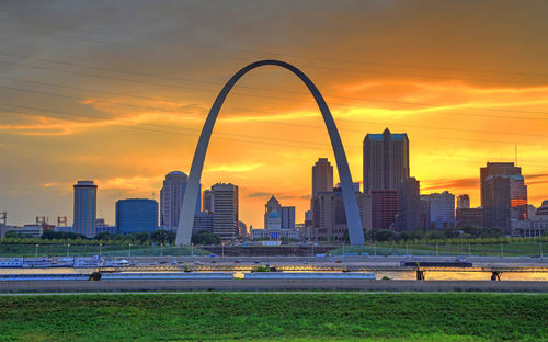 Modern buildings in city against sky during sunset