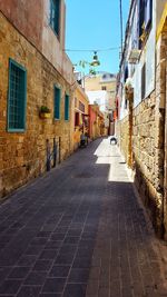 Cobblestone street amidst buildings in city