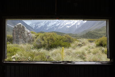 Scenic view of mountains against sky seen through window