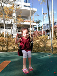 Portrait of smiling girl standing against building