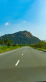 Road by mountain against sky