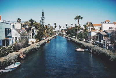 Canal amidst houses against clear sky