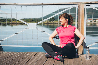 Tired woman sitting on footbridge during sunny day