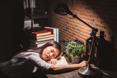 Young woman sitting on table at home