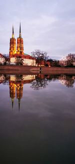 Reflection of building in lake against sky