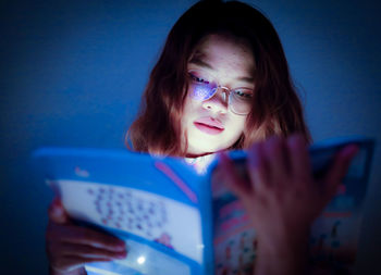 A woman reading in a dark room alone