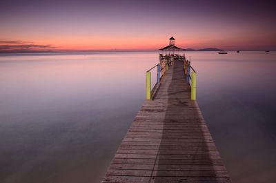 Pier over sea against sky during sunset