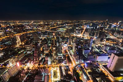 High angle view of illuminated cityscape against sky at night