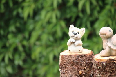 Close-up of toy on tree stump against blurred background
