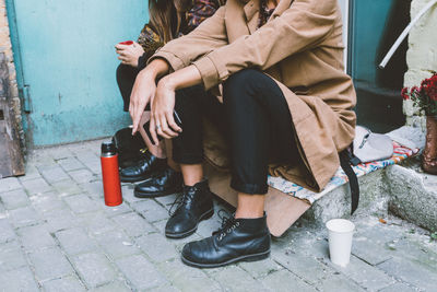 Low section of women sitting outdoors