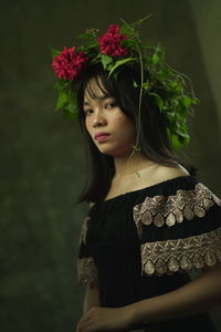 Portrait of a beautiful young woman with red flower