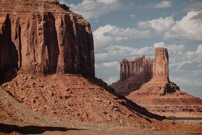 Rock formations on landscape against cloudy sky