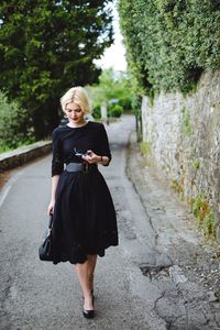 Full length of woman standing on tree stump