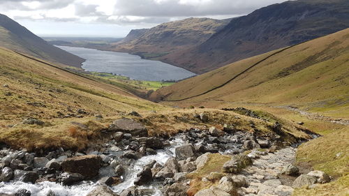 Mountain path and river descent to a lake