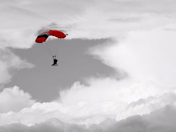 Low angle view of person paragliding against sky