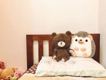 Stuffed toy on bed against wall at home