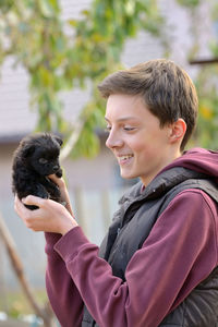 Close-up of boy holding puppy