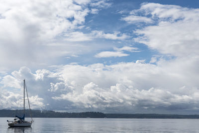 Sailboat moored at sea against sky