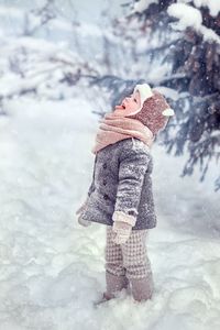 Low section of woman standing on snow covered field