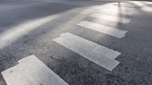 Crosswalk in urban area illuminated by intense day light