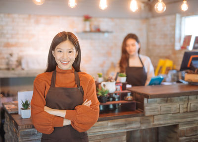 Portrait of beautiful woman smiling while standing in cafe