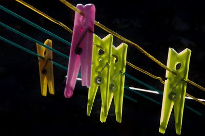 Low angle view of colorful clothespins hanging on clothesline at night