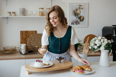 Girl shifts cakes on a dish in the kitchen